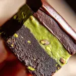 A tray of sliced 5-Ingredient No-bake Pistachio Brownies topped with crushed green nuts