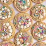 A stack of soft Birthday Cake Sugar Cookies with rainbow sprinkles on a wire rack