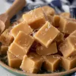 A close up of sliced Traditional Caramel Fudge on a piece of parchment paper.