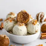 A tray of white chocolate coated Carrot Cake Truffles with orange drizzle and crushed walnuts