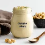Smooth and creamy Cashew Cream Sauce in a glass jar showing a velvety texture.