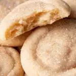 A stack of golden Chewy Sugar Cookies on a white plate with crinkled tops