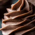 A bowl of fluffy Chocolate Buttercream Frosting with a spatula
