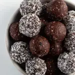 A tray of round Chocolate Coconut Energy Balls coated in shredded coconut