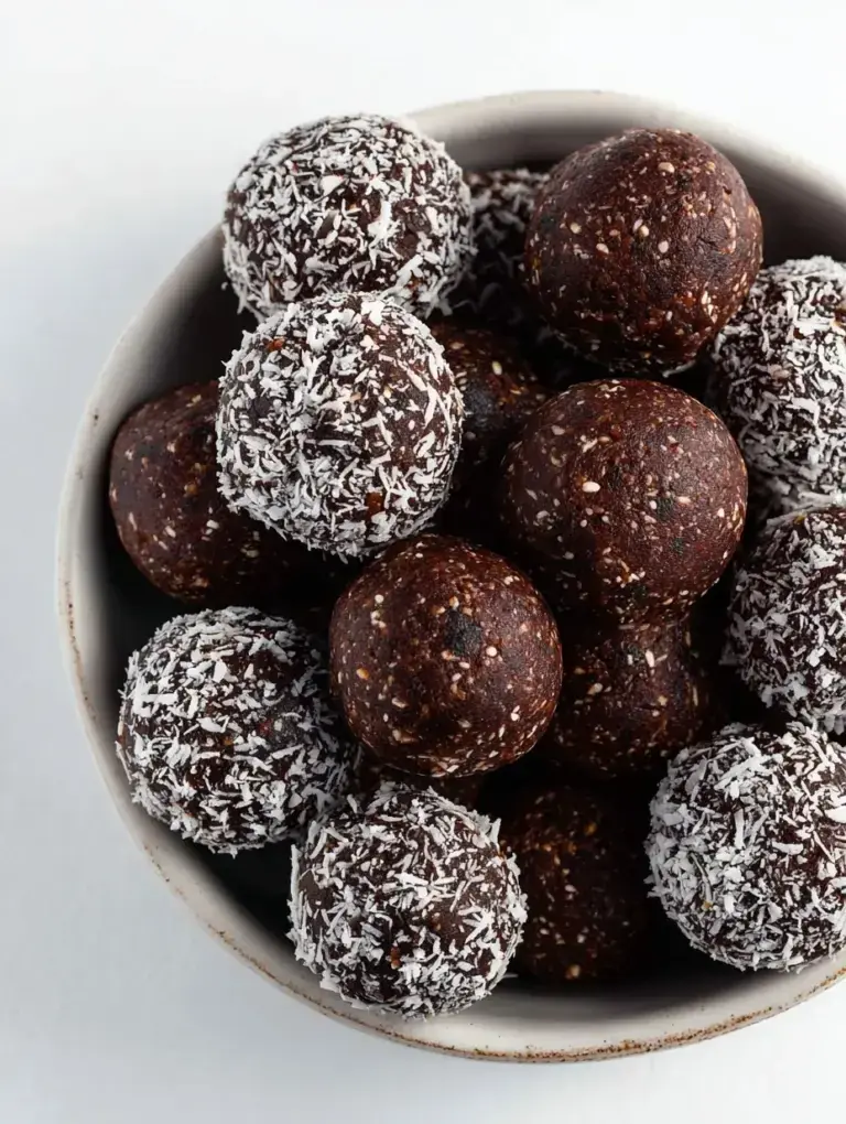 A tray of round Chocolate Coconut Energy Balls coated in shredded coconut