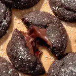 Freshly baked Chocolate Lava Cookies on a tray with one broken open to reveal a molten chocolate center