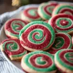 Festive red and white Christmas Pinwheel Cookies stacked on a cooling rack