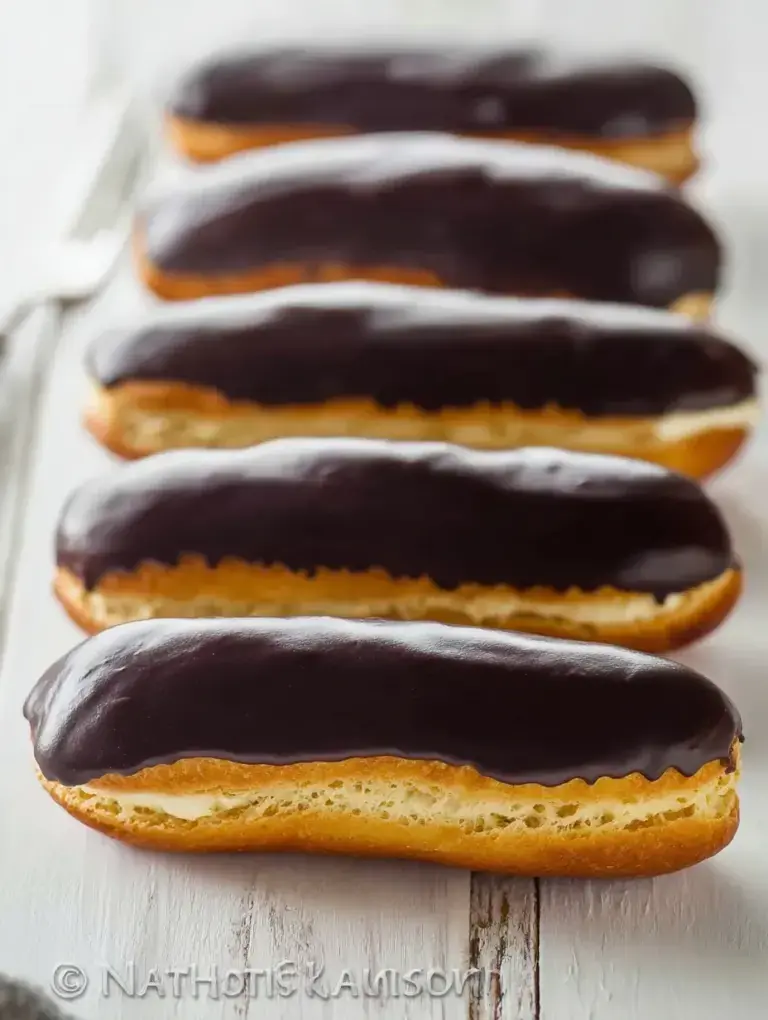 Golden Classic Chocolate Eclairs filled with vanilla cream and topped with shiny chocolate glaze