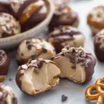 A tray of chocolate-dipped Cookie Dough Pretzel Bites resting on parchment paper