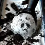 A scoop of homemade Cookies and Cream Ice Cream in a bowl with chocolate cookies
