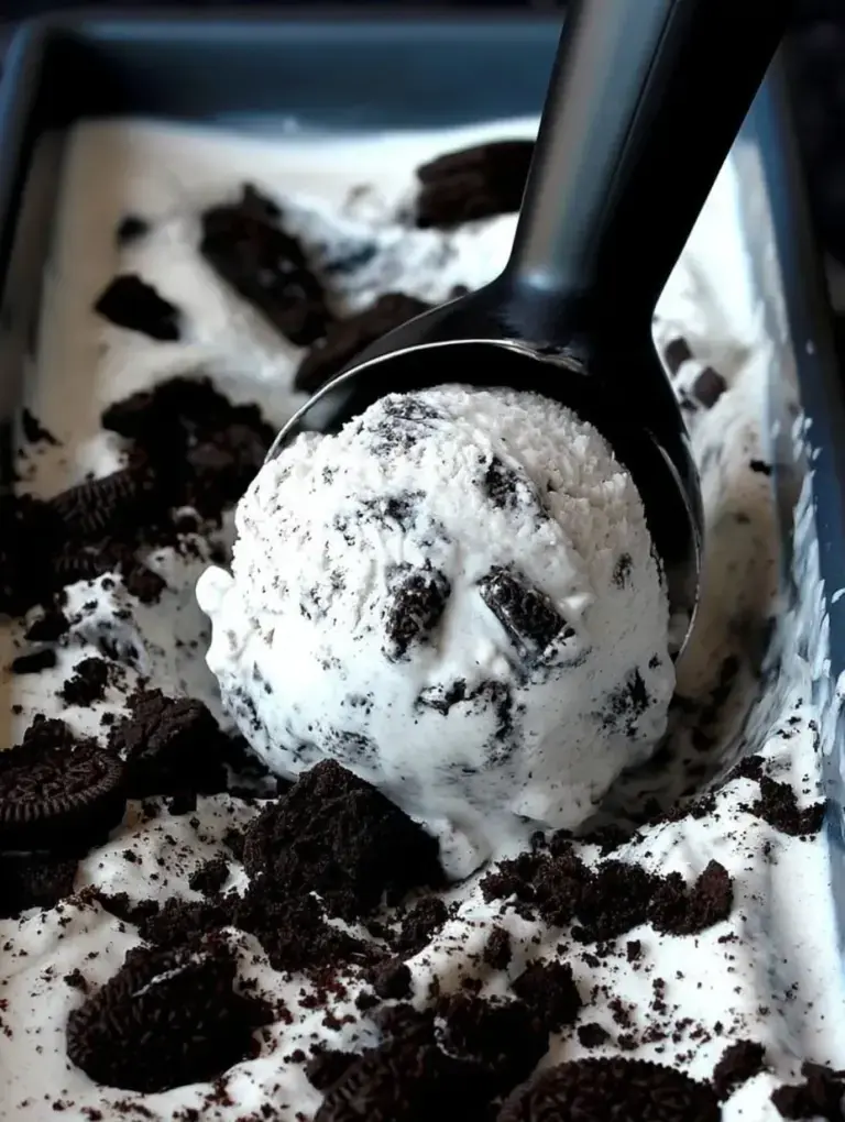 A scoop of homemade Cookies and Cream Ice Cream in a bowl with chocolate cookies