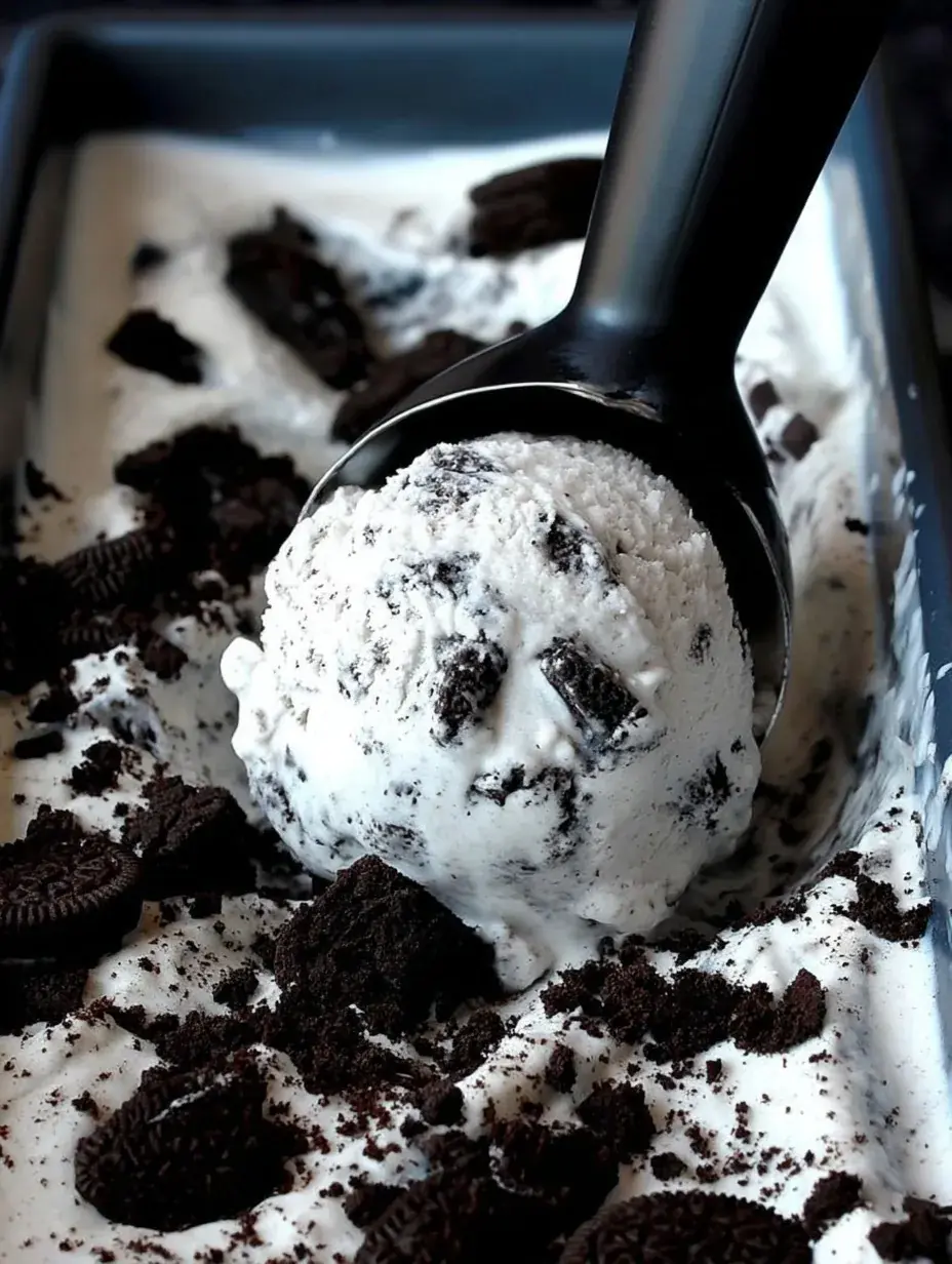 A scoop of homemade Cookies and Cream Ice Cream in a bowl with chocolate cookies