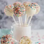 A tray of homemade Copycat Starbucks Birthday Cake Pops with pink coating and white sprinkles