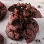 A close up of a thick dark chocolate Crumbl Dark Dream Cookie with melted chocolate chips on top.