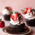 Freshly frosted Decadent Chocolate Strawberry Cupcakes with fresh berries on top