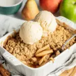 A freshly baked Easy Vegan Apple Crumble in a square baking dish showing bubbling apples and golden oats