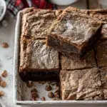 A stack of fudgy Gingerbread Brownies with chocolate chips on a festive plate