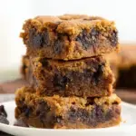 A close up shot of sliced Gooey Chocolate Chip Pumpkin Bars with melty semi-sweet chocolate chips and a soft center.