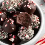 A plate of Healthy Chocolate Peppermint Truffles dusted with dark cocoa powder on a festive table