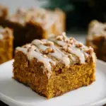 A stack of healthy pumpkin bars with dark chocolate chips on a cooling rack