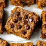 A stack of Healthy Pumpkin Oatmeal Bars showing dark chocolate chips and golden oats