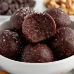 A plate of round No Bake Brownie Bites dusted with cocoa powder
