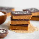 A tray of sliced No Bake Chocolate Peanut Butter Protein Bars showing the dense peanut butter base and smooth chocolate topping.