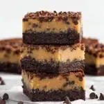 A stack of sliced No Bake Cookie Dough Brownies showing the chocolate base and dough layers