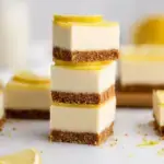 Chilled No-Bake Lemon Cheesecake Bars sliced into squares on a parchment-lined pan
