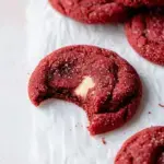 A tray of warm Vegan Red Velvet Cream Cheese Stuffed Cookies showing a peek of the white filling