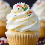 A tray of freshly baked Perfect Vanilla Cupcakes cooling on a wire rack