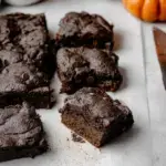 Fudgy Vegan Pumpkin Brownies on a cooling rack with melted chocolate chips