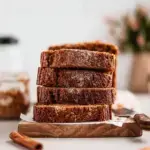 A sliced Vegan Gluten-Free Oil-Free Pumpkin Gingerbread Loaf on a wooden board