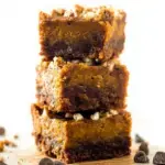A tray of sliced Pumpkin Pie Magic Cookie Bars with toasted coconut and chocolate chips