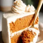 A beautiful homemade Pumpkin Spice Latte Cake with espresso cream cheese frosting on a wooden table.