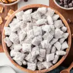 A bowl of powdered sugar coated Puppy Chow (Muddy Buddies) snack mix
