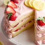 A double layer Strawberry Lemon Cake topped with fresh berries and lemon zest