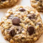 A stack of Best Oatmeal Chocolate Chip Cookies on a cooling rack with chocolate chips melting.