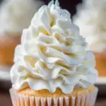 A bowl of fluffy Vanilla Buttercream Frosting with a spatula.