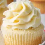 A batch of Classic Vanilla Cupcakes topped with smooth vanilla buttercream frosting and sprinkles.