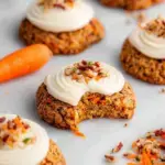 A tray of freshly baked Vegan Carrot Cake Cookies with a white cream cheese drizzle on top.