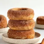 A plate of golden baked Vegan Cinnamon Sugar Donuts coated in sweet cinnamon sugar