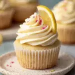 A tray of fluffy Vegan Lemon Cupcakes topped with yellow swirls of frosting and fresh lemon zest.