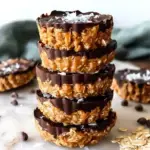Homemade Vegan No Bake Peanut Butter Oat Cups with a glossy chocolate glaze on a cooling rack