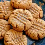 A stack of Vegan Peanut Butter Cookies with classic fork criss-cross marks on a wire cooling rack