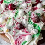 Pieces of White Chocolate Christmas Bark with red and green sprinkles on a parchment lined tray