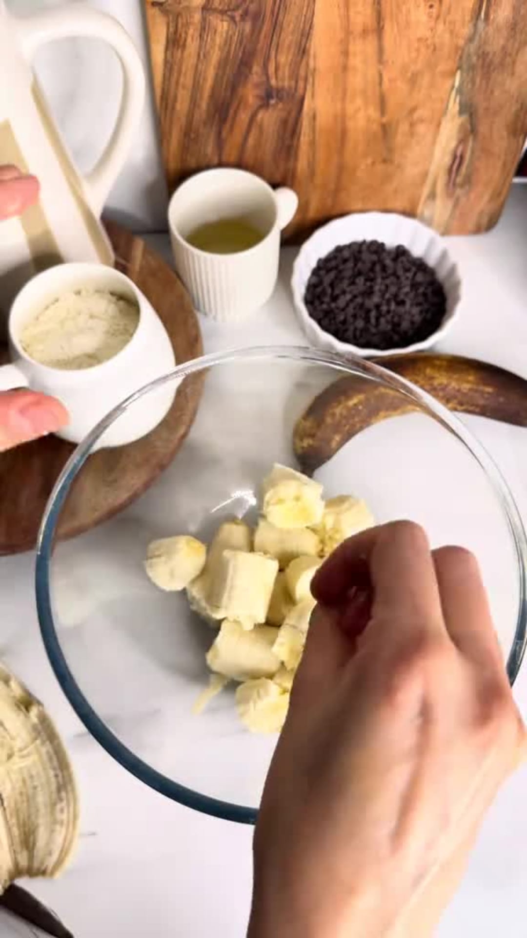 Moist Chocolate Chip Banana Bread - Mashing bananas in glass bowl