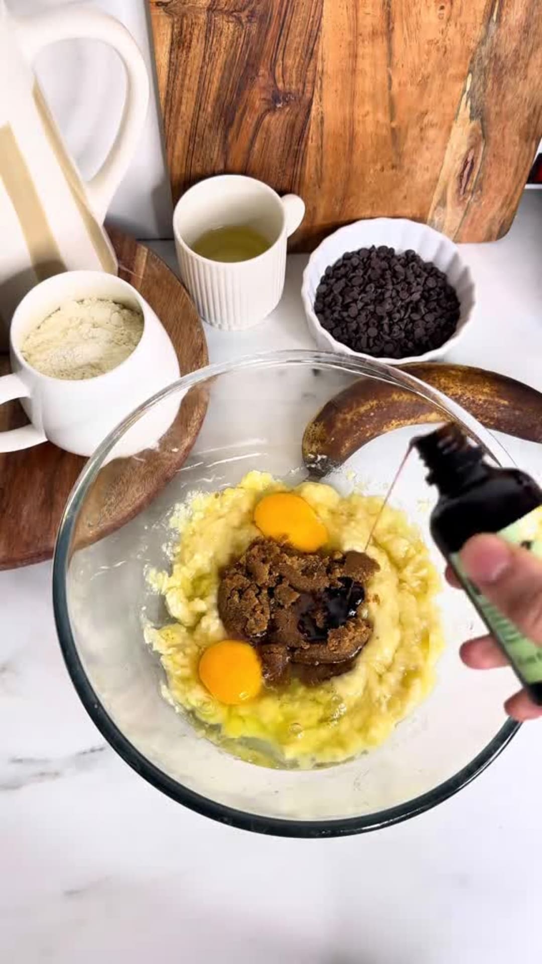 Moist Chocolate Chip Banana Bread - Whisking eggs, sugar, and vanilla into mashed bananas